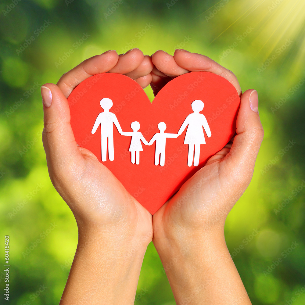 Paper Family and Heart in Hands over Green Background Paper Family and Heart in Hands over Green Background