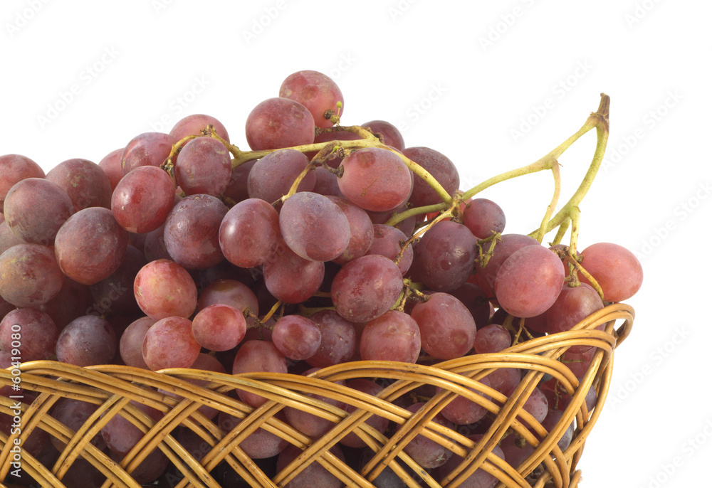 Red grape on branch in brown wicker basket isolated on white Red grape on branch in brown wicker basket isolated on white