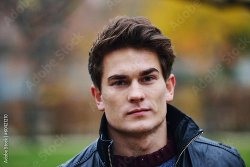 Young stylish guy in park posing