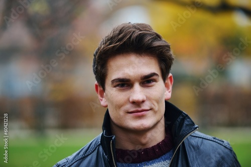 Young stylish guy in park posing