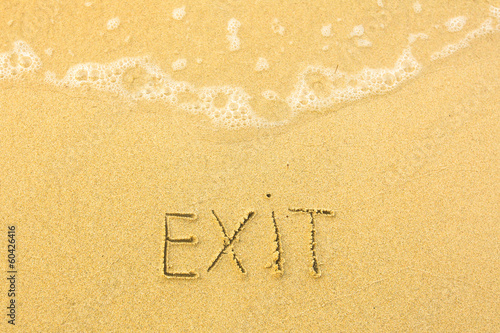 Exit - written in sand on beach texture - soft wave of the sea. © De Visu
