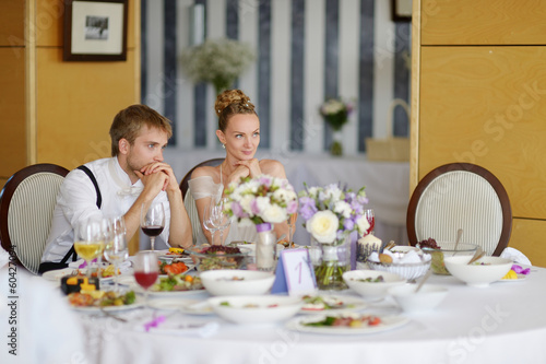 Bride and groom at the reception table © MNStudio