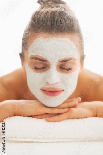 Woman with revitalising mask on face laying on massage table