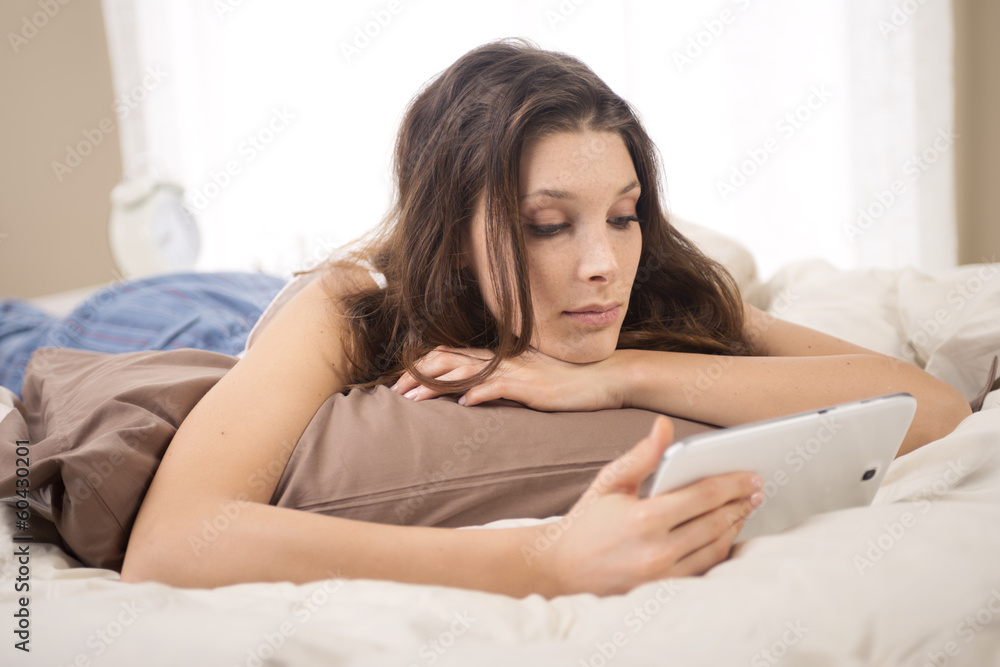 Woman using digital tablet in bed Woman using digital tablet in bed