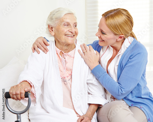 Lachende Seniorin schaut ihre Tochter an photo
