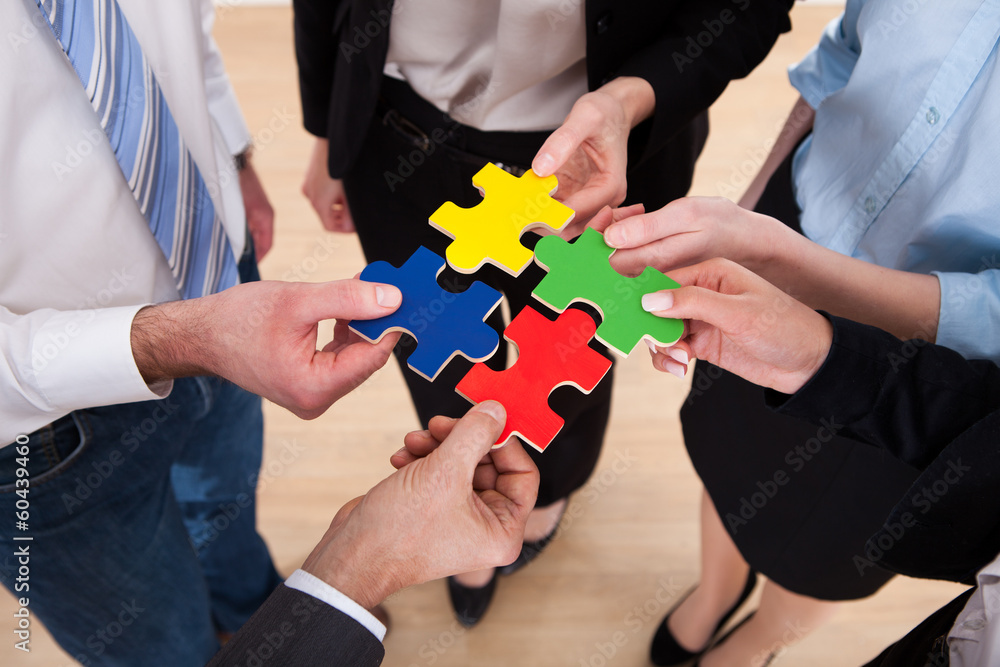 Businesspeople Assembling Jigsaw Puzzle Businesspeople Assembling Jigsaw Puzzle