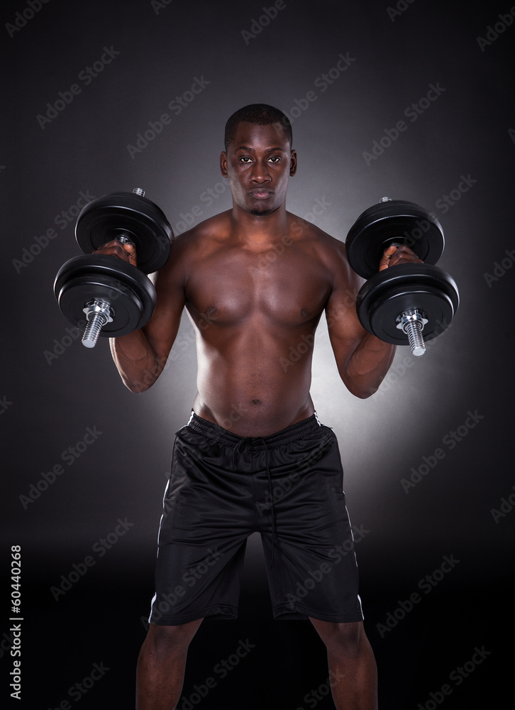 Young African Man Working Out With Dumbbells