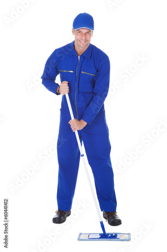 Worker In Boilersuit Cleaning Floor