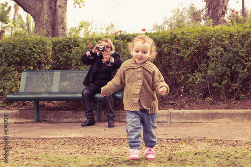 Grandmother photographing baby girl at a park