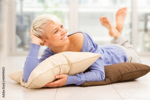 Smiling woman with short hairs laying on a pilow