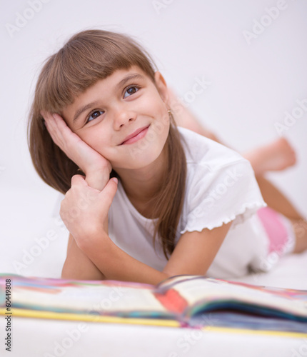 Little girl is reading a book