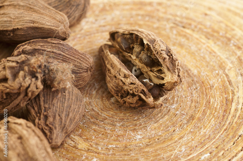 Black cardamom pods on wooden background photo