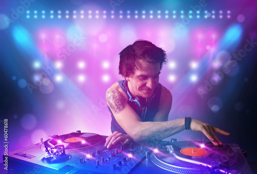 Disc jockey mixing music on turntables on stage with lights and © ra2 studio
