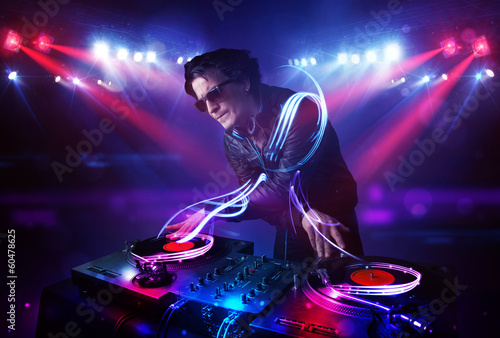Disc jockey playing music with light beam effects on stage © ra2 studio
