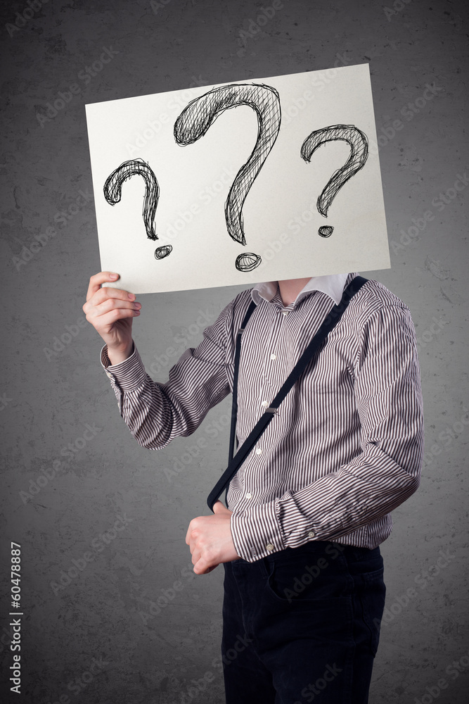 Businessman holding a paper with question marks in front of his Businessman holding a paper with question marks in front of his