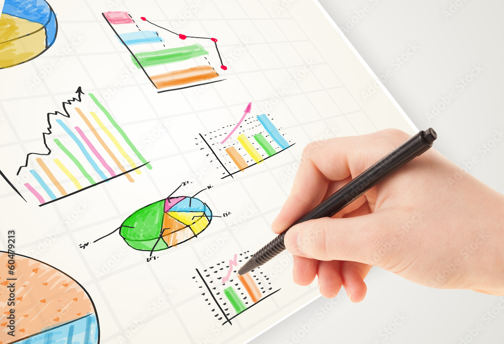 Business person drawing colorful graphs and icons on paper
