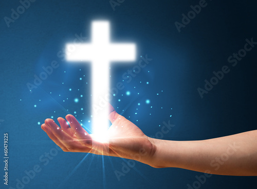 Glowing cross in the hand of a businessman