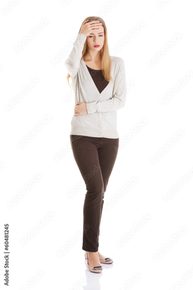 Fototapeta premium Attractive woman is touching her forehead and stomach.