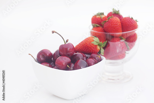 Cherries and strawberry in a ceramic and glass bowl isolated on