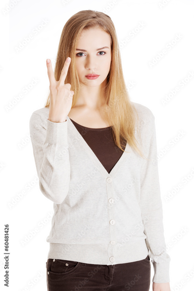 Beautiful casual woman is showing victory sign, two fingers. Beautiful casual woman is showing victory sign, two fingers.