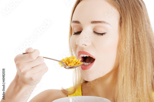 Beautiful caucasian woman eating cereals.