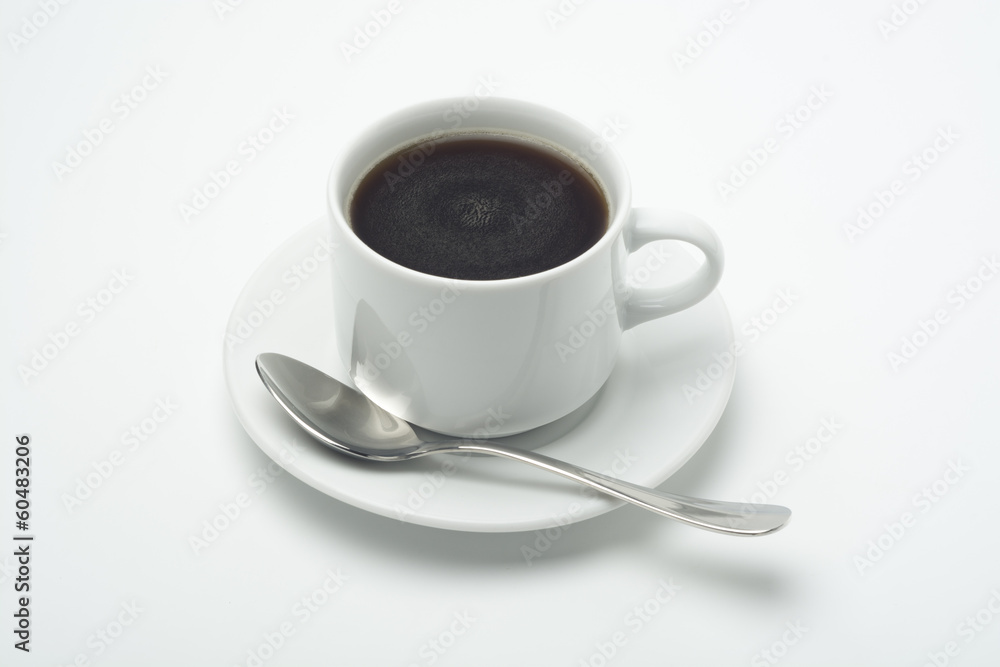 Taza de café con cucharilla en un plato