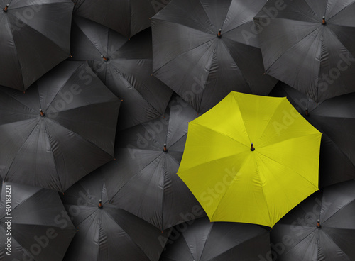 concept for leadership with many blacks and yellow umbrella