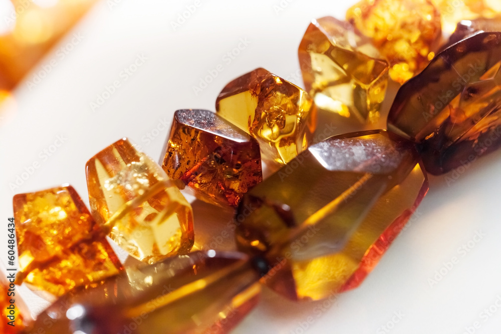 Macro photo of amber beads on white background Macro photo of amber beads on white background