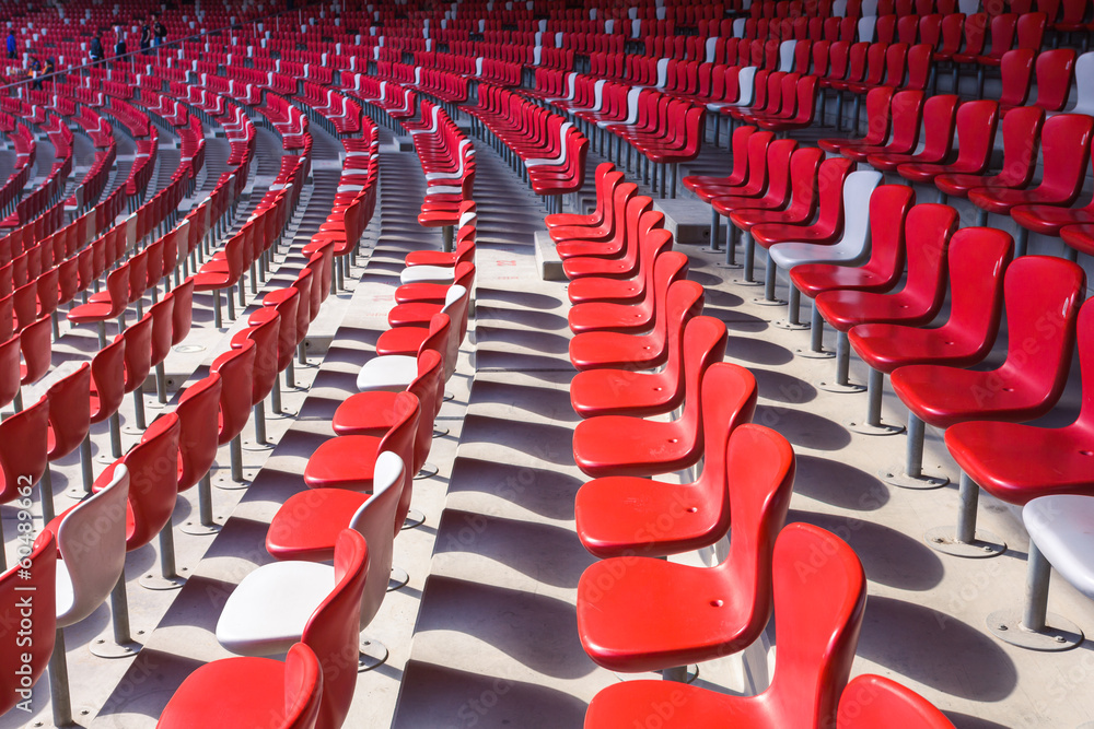 Fototapeta premium Red chairs bleachers in large stadium