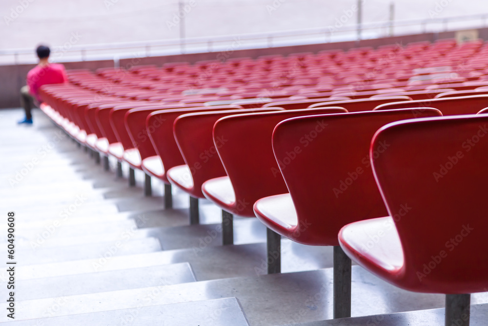 Fototapeta premium Red chairs bleachers in large stadium