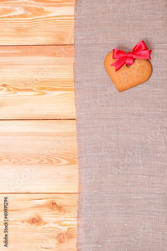 Fototapeta Naklejka Na Ścianę i Meble -  Heart shaped gingerbread cookie over linen cloth