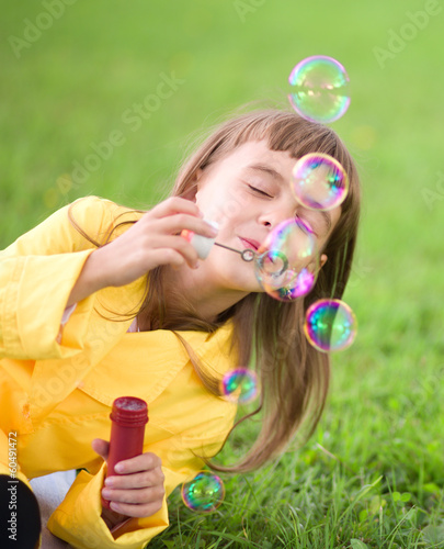 Little girl blowing soap bubbles