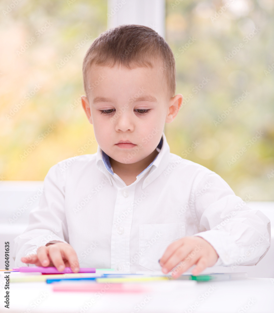 Little boy is drawing on white paper Little boy is drawing on white paper