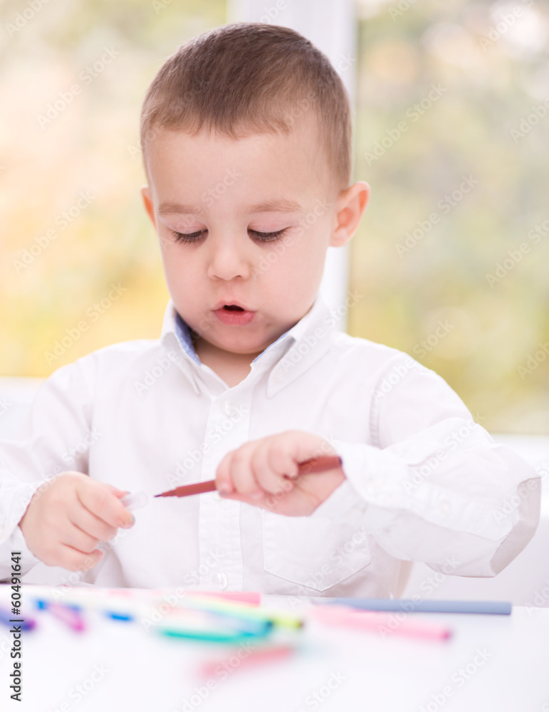 Little boy is drawing on white paper Little boy is drawing on white paper