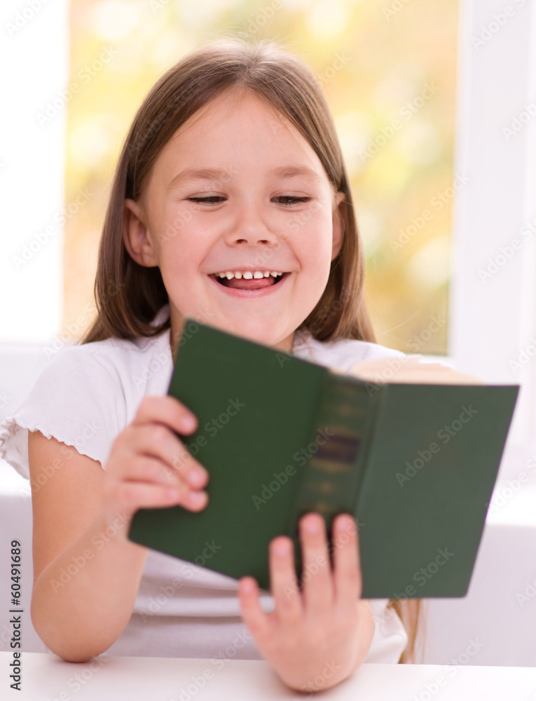 Little girl is reading a book