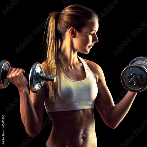 Fitness girl - attractive young woman working out with dumbbells