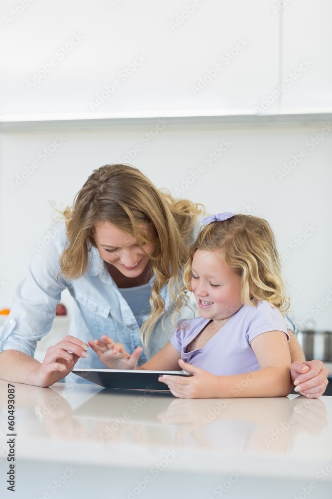Woman and daughter using digital tablet together Woman and daughter using digital tablet together