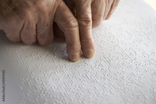 Old woman' s hands, reading a book with braille language