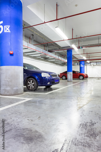 Parking garage, underground interior with a few parked cars