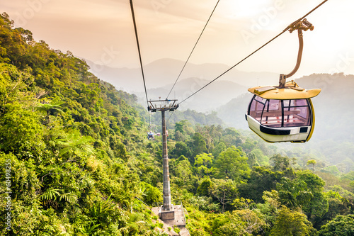 Aerial tramway moving up in tropical jungle mountains photo