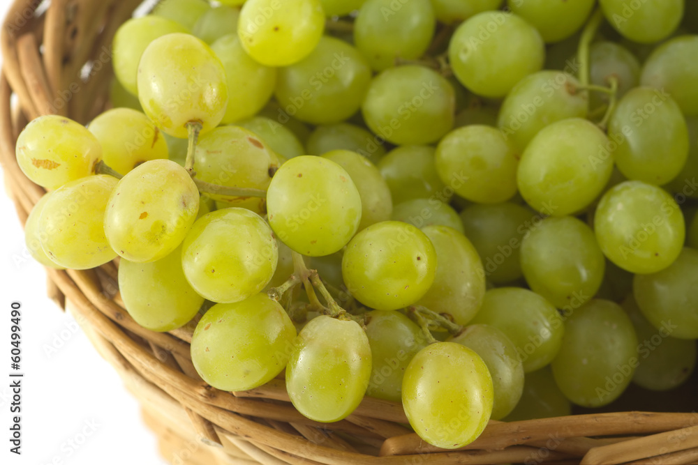 Lot of ripe grape bunches in brown wicker basket closeup Lot of ripe grape bunches in brown wicker basket closeup