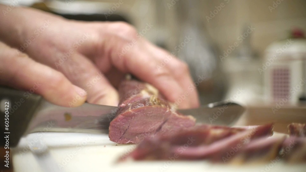 Hand cutting smoked meat with knife Hand cutting smoked meat with knife