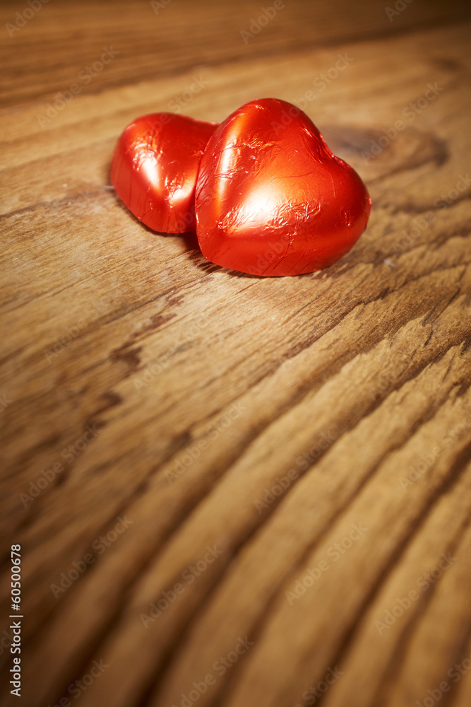 Delicious chocolate hearts on old wood table- focus on heart-sha