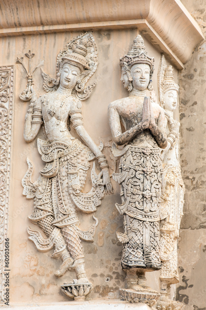 Stone praying women carvings on the wall of the temple in Thaila