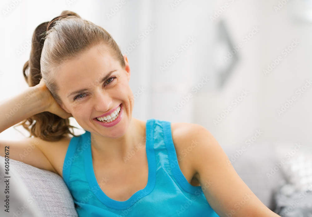 Smiling young woman sitting in living room Smiling young woman sitting in living room