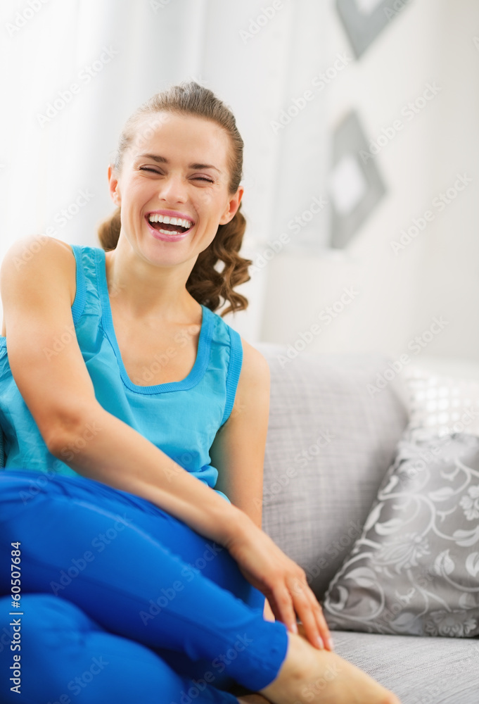 Smiling young woman sitting on sofa Smiling young woman sitting on sofa