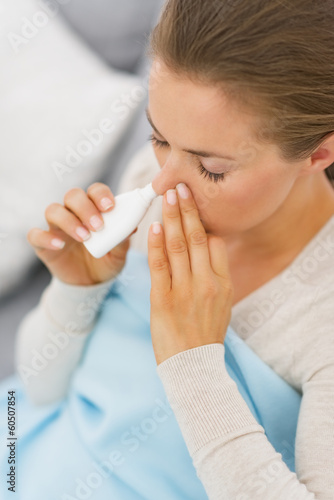 Young woman using nose drops