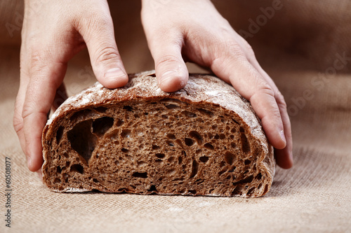 Slice of brown bread with male hands