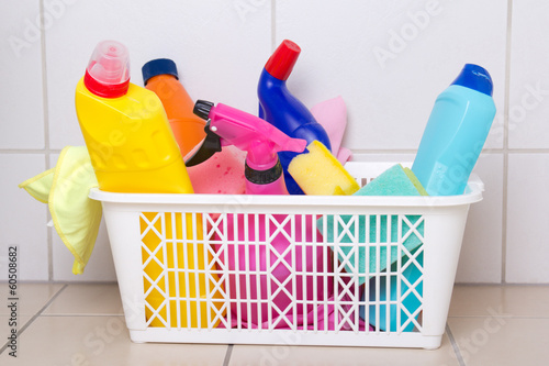 cleaning supplies in plastic box on tiled floor