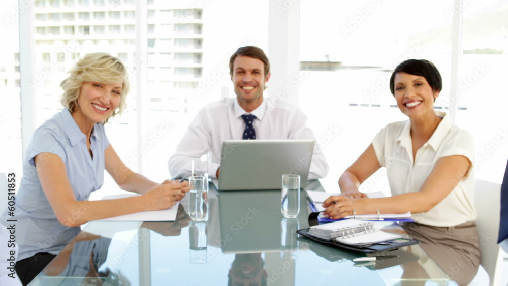 Business people smiling at camera during a meeting Business people smiling at camera during a meeting